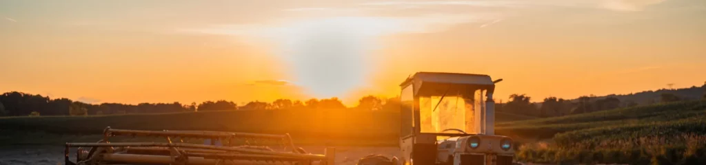 Beautiful rural landscape at sunset, featuring a tractor in the fields — Embrace farm